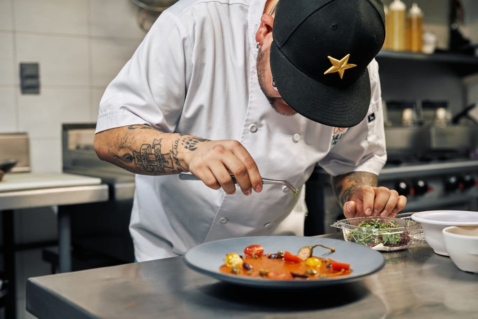 Restoran mutfağında tabak hazırlayan aşçı